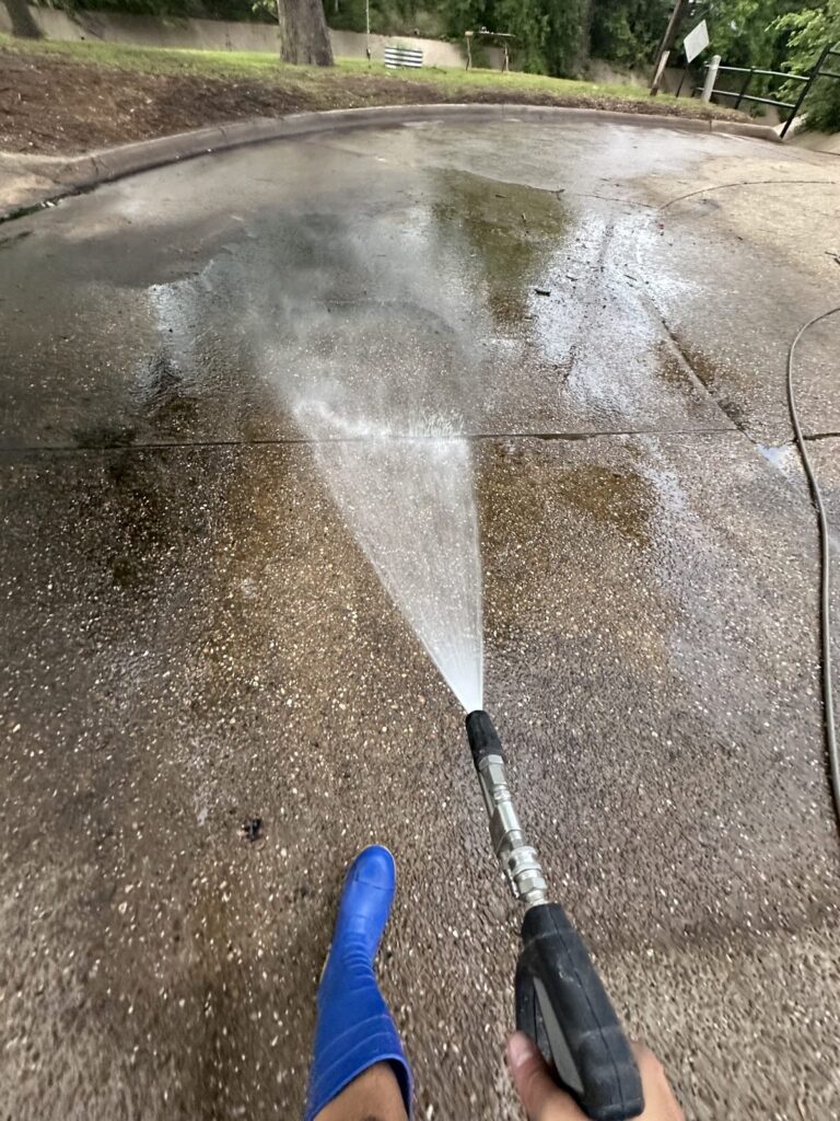 Pressure washing a stained driveway in Bryan, TX