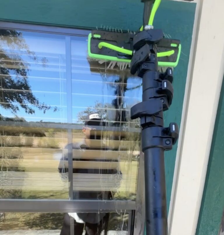 Window cleaning with a water-fed brush after a house wash in Hearne TX