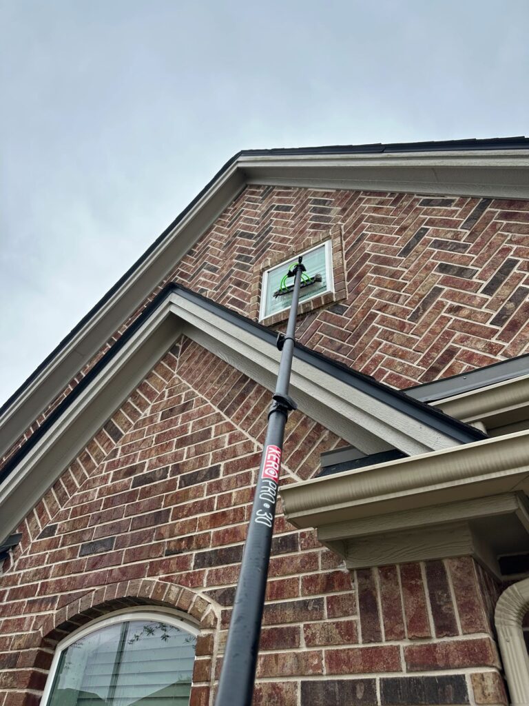 Window cleaning with a water-fed pole on a College Station TX home